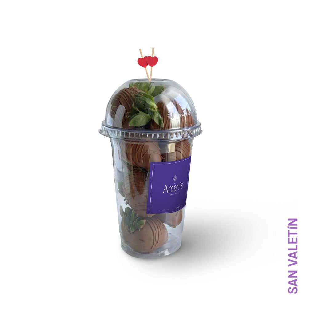 Ocho fresas bañadas en chocolate presentadas en un elegante vaso, acompañadas de dos mondadientes en forma de corazón, perfectas para un dulce gesto de amor.